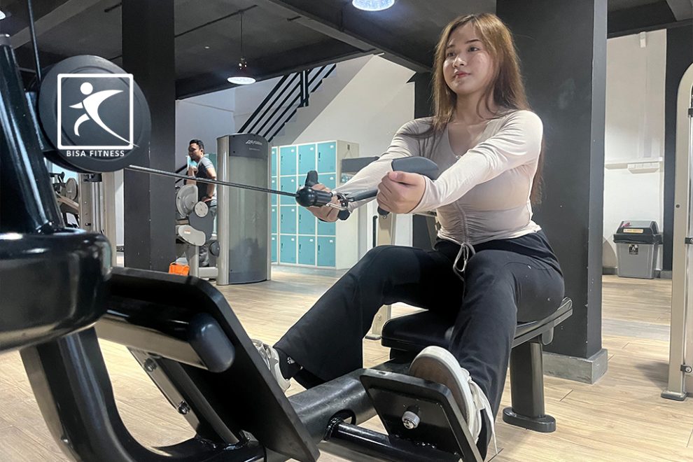 Seorang member di BisaFitness, gym terkemuka di Pulau Batam, sedang melatih otot punggung dengan menggunakan cable row machine. Dengan postur yang baik, ia menarik kabel ke arah tubuhnya, memperkuat otot punggung dan meningkatkan kebugaran fisiknya. BisaFitness menyediakan berbagai peralatan modern untuk mendukung berbagai jenis latihan bagi anggotanya.