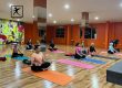 Peserta kelas yoga di BisaFitness, gym di Pulau Batam, sedang berpose duduk bersila dalam posisi meditasi. Dengan mata tertutup dan tubuh yang tenang, mereka menciptakan suasana damai dan fokus, menunjukkan manfaat mental dan fisik dari latihan yoga. BisaFitness menawarkan kelas yoga untuk meningkatkan kesehatan dan kebugaran anggota