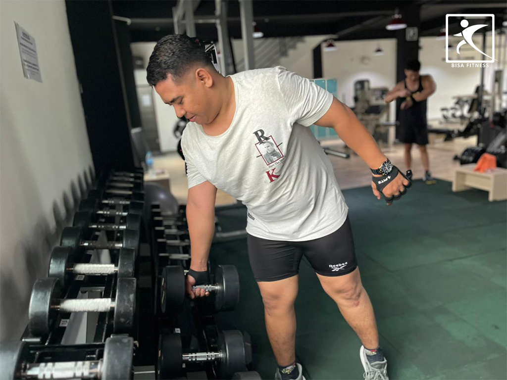 Member BisaFitness di Batam mengembalikan dumbbell ke rak setelah digunakan, kebiasaan sederhana yang menjaga gym tetap rapi, nyaman, dan aman untuk semua member di Tiban dan Batam Center.