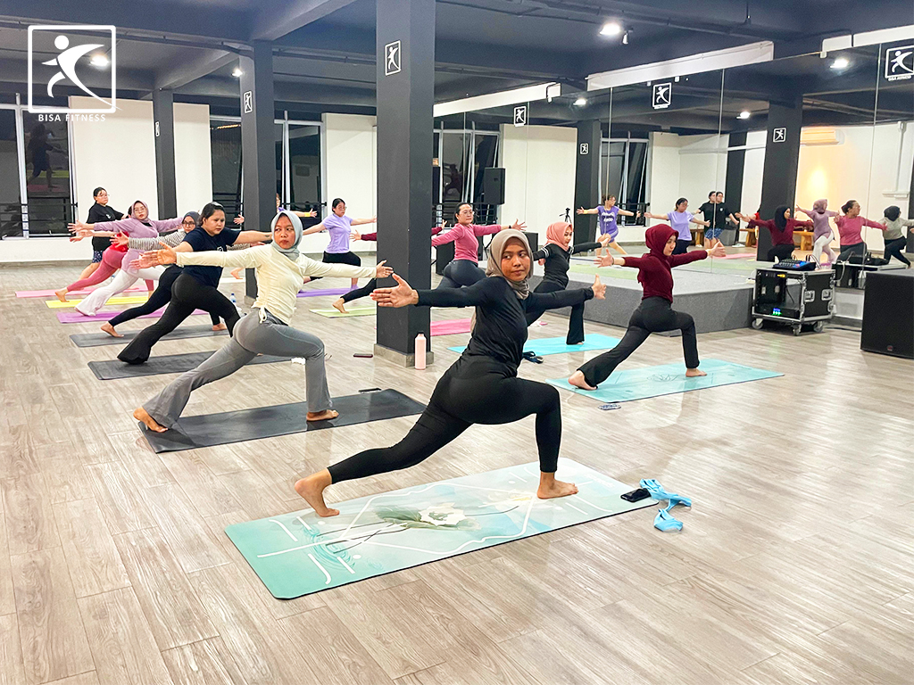 Kelas Yoga di BisaFitness Batam dengan instruktur dan peserta bersemangat, menunjukkan suasana gym yang ramah, affordable, dan menyenangkan di cabang Tiban dan Batam Center.”
